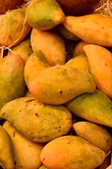 Ripe mangoes in a box at a local market. Fresh tropical fruits with vibrant yellow-orange skin. Juicy, sweet, and ready to eat.