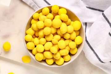 Bowl with cheese coated peanuts on light background