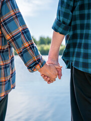 Senior couple hold hands. Close-up. Selective focus.