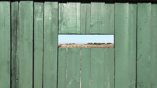 Wooden birdwatching shelter or bird hide with benches and viewing windows overlooking local wetlands or conservation in Williamstown, Melbourne Australia.  Concept of wildlife observation.