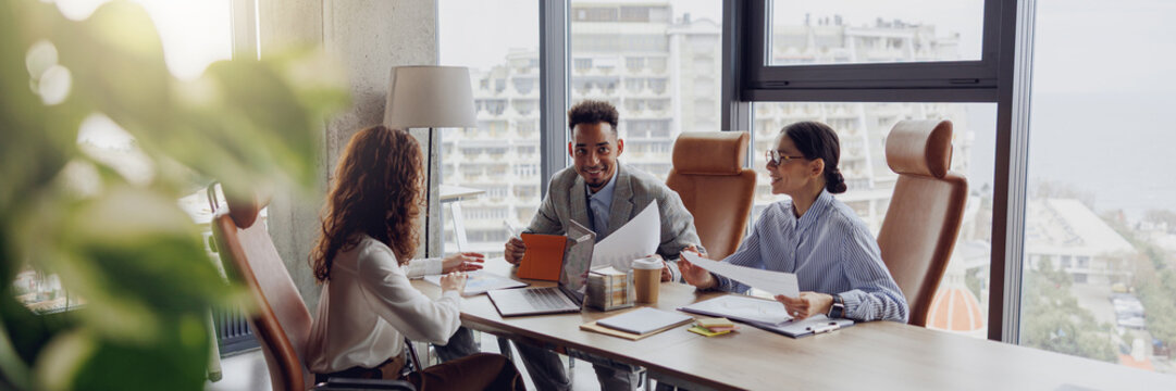 A professional team is engaged in an indepth discussion about strategies in a bright, modern conference room