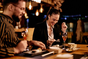Obraz na płótnie Canvas Young Couple Enjoying Sushi Together at a Modern Restaurant Setting