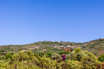 Obraz premium House in hillside landscape with blue sky France Corsica 18 June 2025