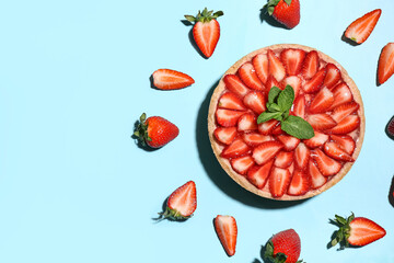 Sweet strawberry tart with mint and fresh berries on blue background
