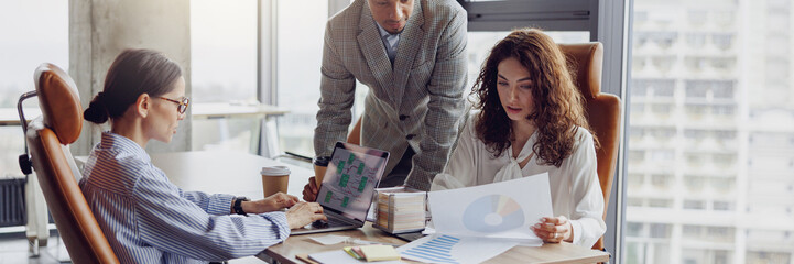 A dynamic and engaged team is actively discussing various strategies in a bright, modern workspace environment © Yaroslav Astakhov