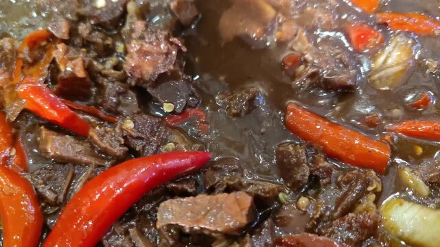 Close up shot of Indonesian-style black pepper beef (sapi lada hitam) served as a savory Asian dish. The tender beef slices are stir-fried with black pepper sauce, vegetables, and seasonings, creating