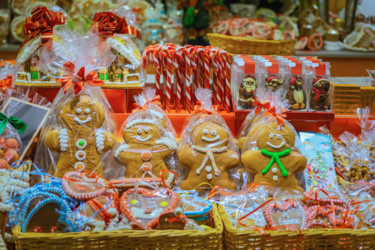 Gingerbread cookies and candy display. Big gingerbread cookies and candy canes wrapped for sale at colorful Christmas market stall. Concept of festive sweets and traditional holiday treat - Powered by Adobe