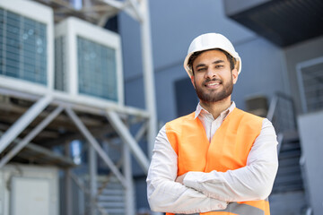 Confident construction worker with a hard hat at an industrial site