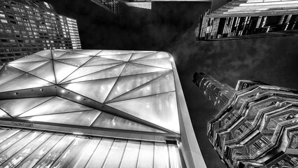 Urban scene showing towering Hudson Yards high-rises at night with modern architecture and glowing windows