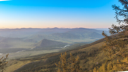 A stunning sunset over a mountain landscape with a meandering river, lush greenery, and warm colors, embodying nature's beauty and tranquility.