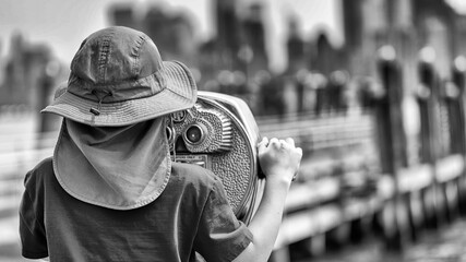 Young woman sightseeing and exploring cityscape of NYC from Liberty Island observation point
