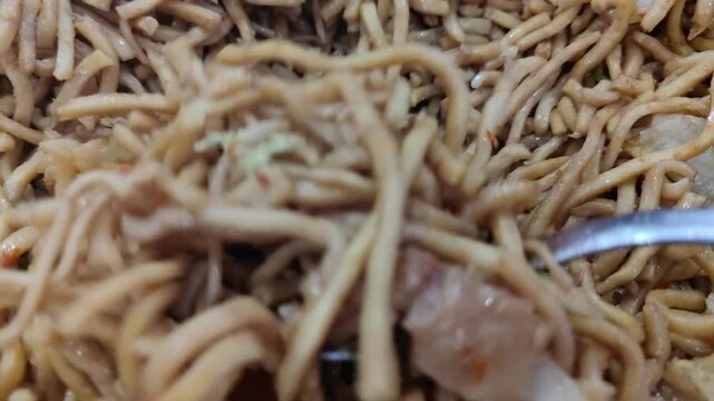 Close up shot of Indonesian fried noodles, known as mie goreng. A delicious and popular Asian street food dish made with stir-fried noodles, vegetables, and savory seasonings.