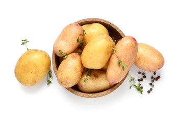 Wooden bowl with raw baby potatoes, thyme and peppercorns on white background