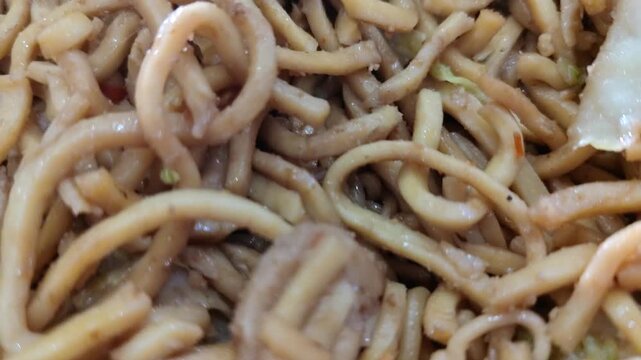 Close up shot of Indonesian fried noodles, known as mie goreng. A delicious and popular Asian street food dish made with stir-fried noodles, vegetables, and savory seasonings.