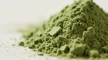 Obraz premium Close-up view of matcha tea powder in macro perspective, finely ground green texture illuminated softly against neutral background