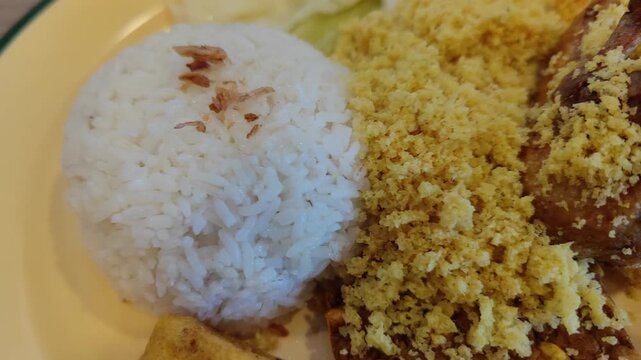 Traditional Indonesian fried chicken served with steamed white rice and crispy crumbs (ayam goreng kremes). A popular local dish known for its crunchy texture and savory flavor