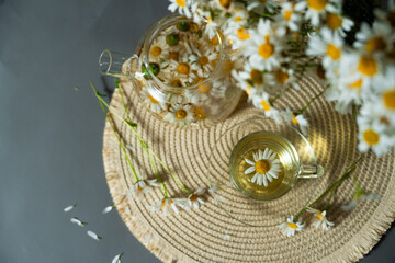 Chamomile infusion in transparent jar and cup with bouquet. Herbal product promotes balance, herbal product enhances health, herbal product ideal for lifestyle blogs and wellness packaging.