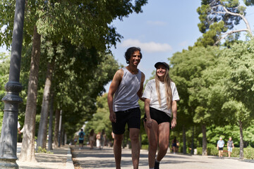 Fototapeta premium Happy couple walking and smiling in a sunny park