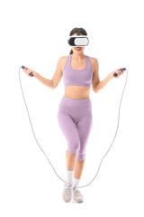 Obraz premium Sporty young woman in VR glasses exercising with skipping rope on white background