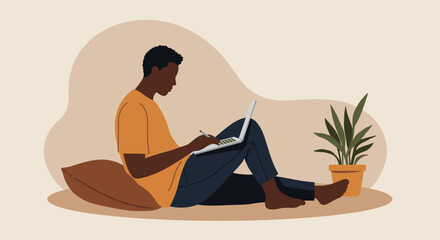 A young Black man comfortably works on his laptop at home, sitting on the floor with a pillow, ideal for remote work, online learning, or casual lifestyle.