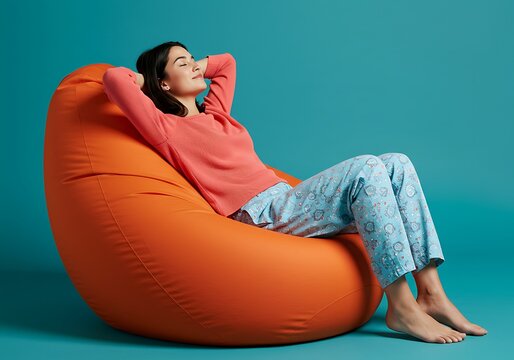 Relaxed woman lounging in a bright orange beanbag chair - Powered by Adobe