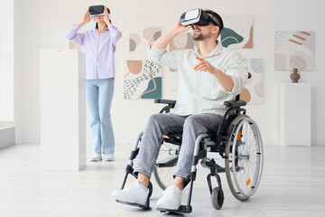 Young man in wheelchair with VR glasses visiting modern art gallery