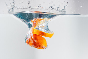 Vitamin C, orange piece dropped into water