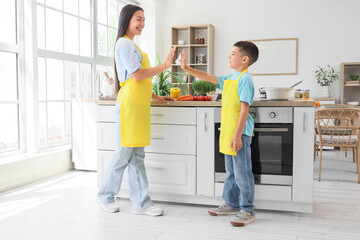 Fototapeta premium family bonding and healthy lifestyle, mother and son cooking together in a modern kitchen