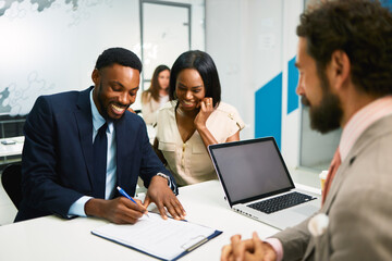 Business man signing contract with manager and partner watching
