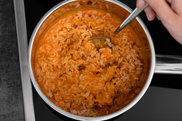 Cook rice with chicken in tomato sauce in a pot
