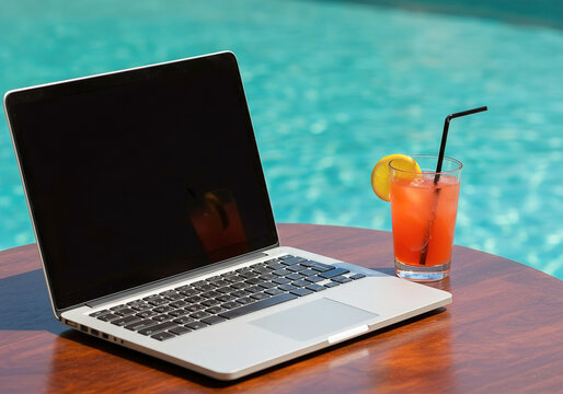 Working by the pool with a refreshing drink and a laptop in the sun during summer