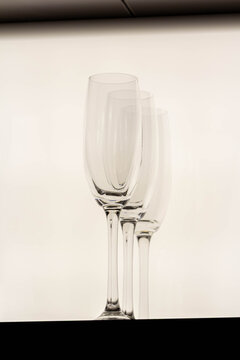 An empty, elegant champagne glass stands beside a bottle, with a clean and bright white background. A symbol of upcoming celebration.