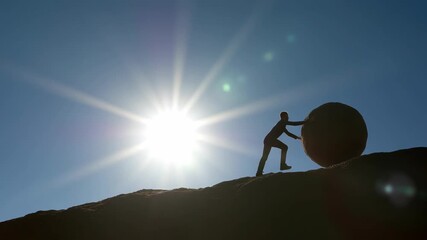 Silhouette of a person pushing a large round stone uphill against a bright sunlit sky, symbolizing effort and perseverance.