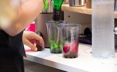 bartender making lemonades using fruit syrups