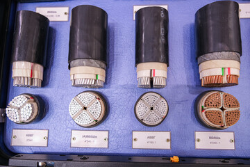 A display of four different types of wire, each with a different color and size
