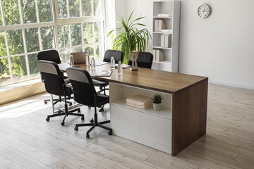 Interior of conference hall with desk, shelf unit and palm plant