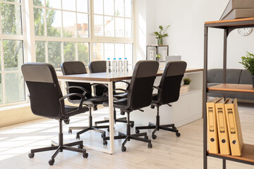 Interior of conference hall with desk, shelf units and plants