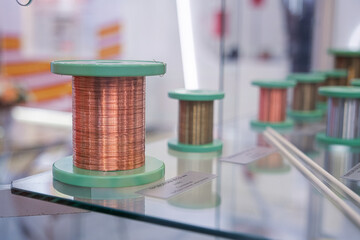 Spool of copper wire on display for industrial and electrical application. Electrical cable material for manufacturing and construction.