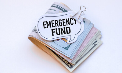 A stack of money with a sign that says Emergency Fund