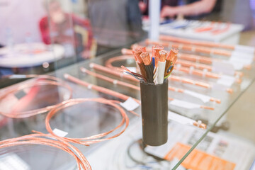 Bundled electrical copper wires and cables displayed on a transparent surface, used for power, telecommunication, and construction.