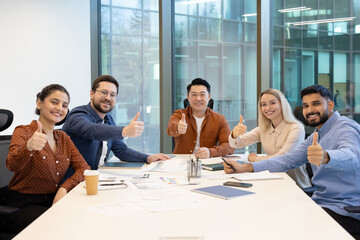 Team having a positive meeting with thumbs up gesture in modern office
