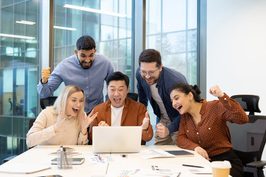 Excited team celebrating success together during a business meeting in an office - Powered by Adobe
