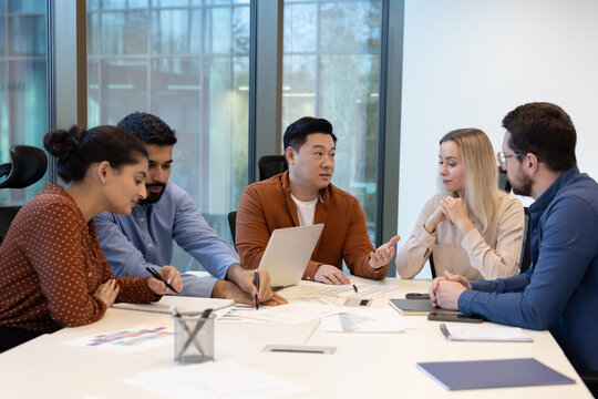Group of professionals discussing a project in a modern office setting