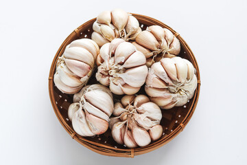 Top view of a pile of fresh garlic bulbs in a basket. Essential for cooking and adding robust flavor to culinary creations.