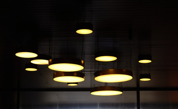 Group of Modern Circular Pendant Lights Hanging from a Ceiling - Powered by Adobe