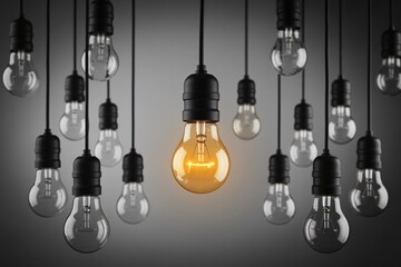 One glowing light bulb among many, standout idea, innovation and leadership, creativity concept background.