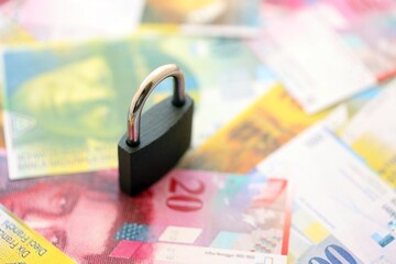 Swiss franc banknotes and padlock. The current francs money bills with lock lies in big amount