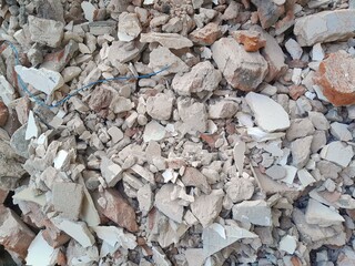 A pile of broken red bricks and fragments of concrete. Pile of debris of a torn down building