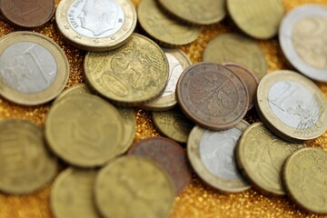 Big amount of euro coins on golden glitter background