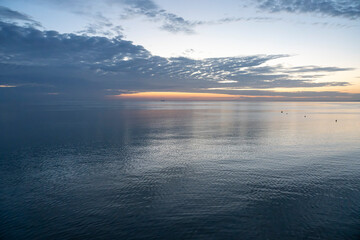 Luc-Sur-Mer, France - 08 07 2025: Panoramic view of the sunrise over the sea with reflections of colorful light